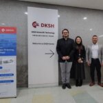 Vier Personen vor einem DKSH-Logo und einem Banner zur 3D-Siebdrucktechnologie, Symbol der Kooperation zwischen Exentis und DKSH in Südkorea