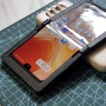 Ein von Lan Bowen selbstgebautes faltbares Smartphone mit 3D-gedrucktem Gehäuse liegt auf einer Schneidematte