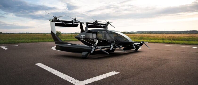 Vertiia VTOL mit 3D-gedrucktem Wärmetauscher auf Startplatz bei Tageslicht Seitliche Ansicht des Vertiia VTOL-Flugzeugs auf einem Startplatz mit mehreren Rotoren und großzügigem Kabinendesign