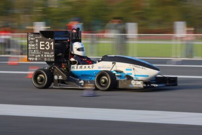 Formelfahrzeug eines Rennteams mit im Metall-3D-Druck gefertigten Komponenten von BLT fährt auf der Rennstrecke