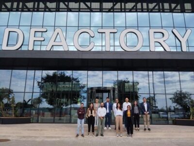 Gruppenfoto des ECOSISTEMA+GO-Konsortiums vor dem DFactory-Gebäude in Barcelona, Fokus auf nachhaltige 3D-Druck-Initiativen