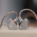 Zwei TitanIEM In-Ear-Kopfhörer aus 3D-gedrucktem Titan mit transparentem Kabelanschluss