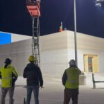 Bauarbeiter beobachten den 3D-Druck eines Supermarkt-Anbaus bei Nacht auf dem Parkplatz eines Walmart-Marktes in Huntsville