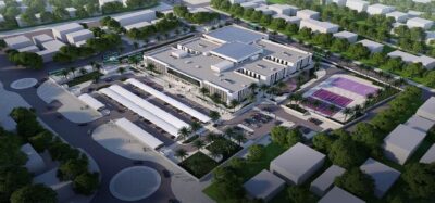 Luftbild einer modernen, im 3D-Druck entstehenden Schule in Katar mit Sportplatz und Parkbereich