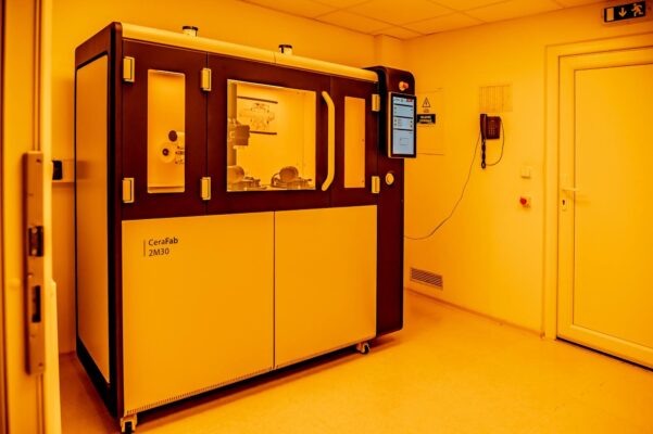 Industrieller 3D-Drucker CeraFab Multi 2M30 in einem Laborraum unter gelbem Licht