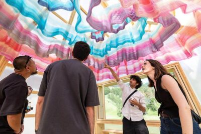 Gruppe von Besuchern betrachtet die bunte, recycelbare 3D-gedruckte Decke im ETH Zürich Projekt